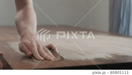 man hand sanding black walnut wood table 80805113
