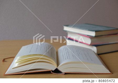 見開き本とテーブルに詰まれた本の素材写真 80805472