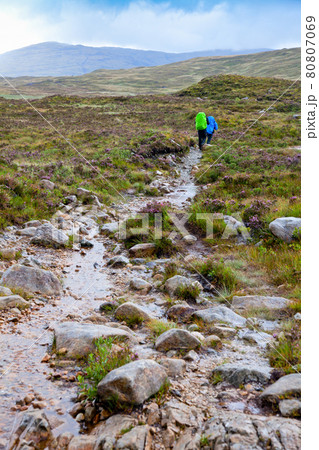 Couple hiking along a trail on a rainy day 80807069