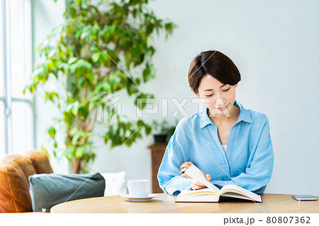 リビングでコーヒーを飲みながら読書をするミドルの女性 リビングでコーヒーを飲みながら読書をするミドルの女性 80807362