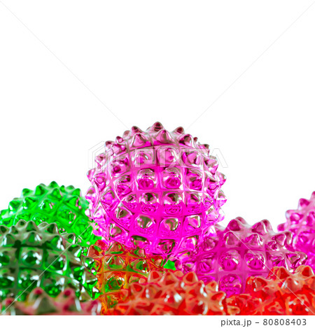 A purple glass ball with spikes rests on other colored balls similar to the covid virus. 3d rendering A purple glass ball with spikes rests on other colored balls similar to the covid virus. 3d rendering 80808403