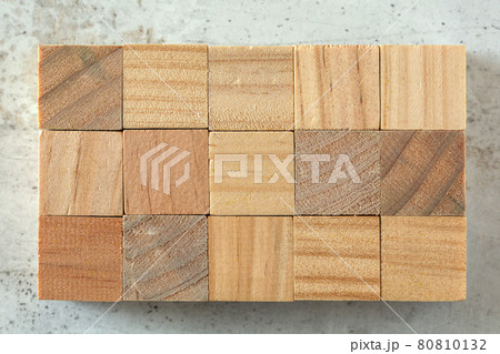 Top view - 15 small wooden cubes arranged to 3 x 5 grid, on concrete board. Letters can be added. 80810132