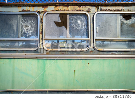 Abandoned old bus side view. Vintage pattern with peeled paint and broken glass. 80811730