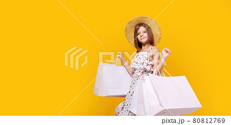 Portrait Of Joyful Teen Girl In Straw Hat With Bright Shopping Bags Over Yellow Background Portrait Of Joyful Teen Girl In Straw Hat With Bright Shopping Bags Over Yellow Background 80812769