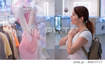 Caucasian woman looking at a shop window and dreaming about a dress. 80814717