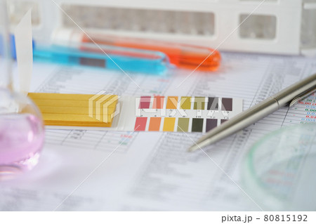 Test tubes with blue and orange liquid with test results on table 80815192
