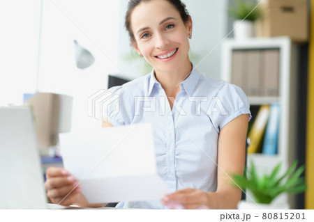 Beautiful smiling woman holding document letter in hands closeup Beautiful smiling woman holding document letter in hands closeup 80815201