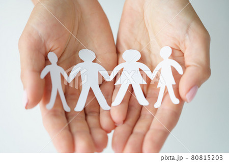 Paper figures of family are held in palms closeup Paper figures of family are held in palms closeup 80815203