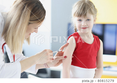 Doctor injects little girl in shoulder closeup Doctor injects little girl in shoulder closeup 80815279