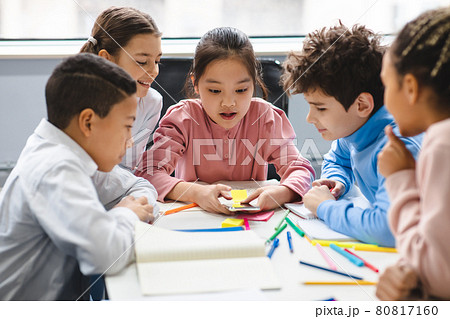 Diverse small schoolchildren using mobile phone at classroom Diverse small schoolchildren using mobile phone at classroom 80817160