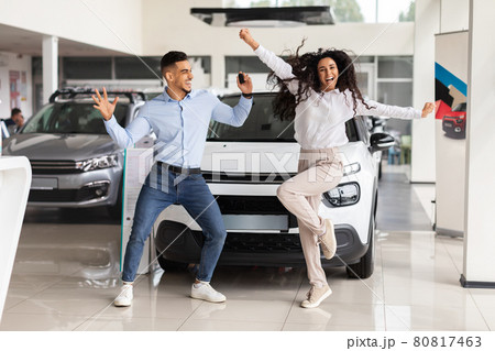 Emotional young couple dancing in car saloon, holding key Emotional young couple dancing in car saloon, holding key 80817463