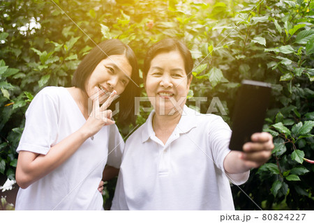 Asian woman selfie with mobile phone together,Enjoying at nature outdoor Asian woman selfie with mobile phone together,Enjoying at nature outdoor 80824227