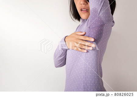 Asian woman with odor sweating,Female smelling or sniffing her armpit,Bad smell,Copy space for text and white background 80826025