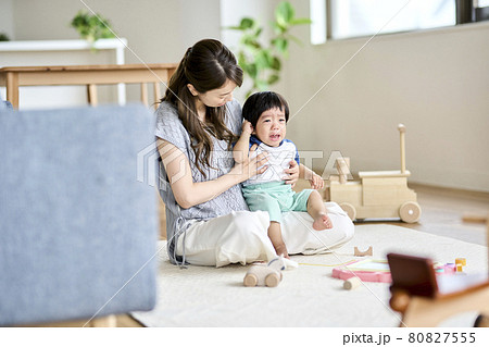 イヤイヤ期の1歳半の息子をあやす母親の写真素材