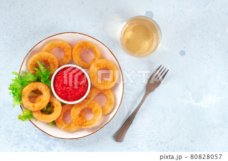 Squid rings. Deep fried calamari rings with ketchup, lettuce, and white wine 80828057