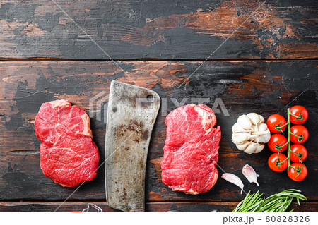 Rump steak organic meat cut, raw marbled beef steak, with old butcher knife cleaver, and seasonings On dark wooden rustic table, top view with space for text. Rump steak organic meat cut, raw marbled beef steak, with old butcher knife cleaver, and seasonings On dark wooden rustic table, top view with space for text. 80828326