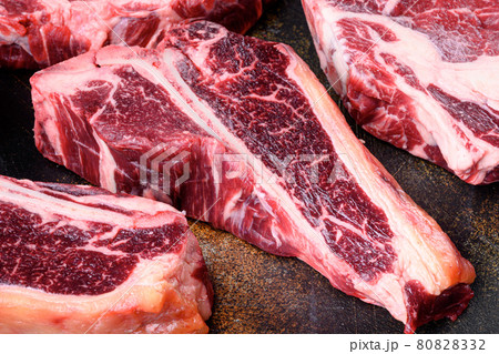 Organic raw beef fresh meat, on old dark rustic background, T bone cut Organic raw beef fresh meat, on old dark rustic background, T bone cut 80828332