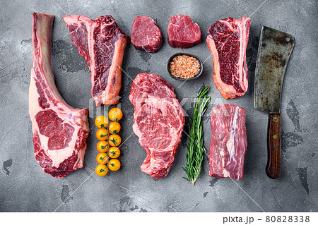 Raw beef meat steaks, tomahawk, t bone, club steak, rib eye and tenderloin cuts, on gray stone background, top view flat lay Raw beef meat steaks, tomahawk, t bone, club steak, rib eye and tenderloin cuts, on gray stone background, top view flat lay 80828338