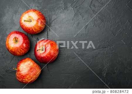 Red apple, on black dark stone table background, top view flat lay, with copy space for text 80828472