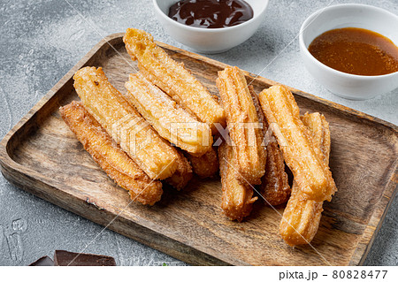 Churros with caramel Traditional Spanish cusine, on gray background 80828477