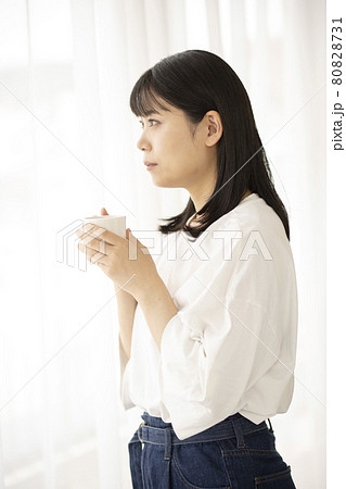 屋内の窓際でコーヒーカップを持っている女性 80828731