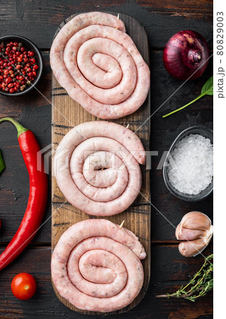 Raw meat sausage, on old dark wooden table background, top view flat lay Raw meat sausage, on old dark wooden table background, top view flat lay 80829003