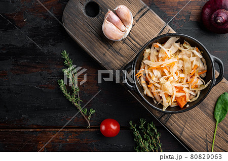 Sauerkraut preserving, on old dark wooden table background, top view flat lay Sauerkraut preserving, on old dark wooden table background, top view flat lay 80829063