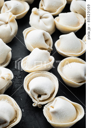 Frozen dumplings tortellini and ravioli, on black background 80829169