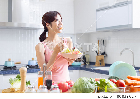 female holding salad in kitchen 80833627