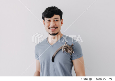 Happy man with his shy Sugar Glider climbing on his body. Happy man with his shy Sugar Glider climbing on his body. 80835179