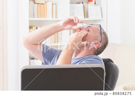 Man applying eye drops 80838275