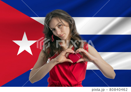 Love Cuba A girl holds a heart on her chest in her hands against the background of the flag of Cuba The concept of patriotism Love Cuba A girl holds a heart on her chest in her hands against the background of the flag of Cuba The concept of patriotism 80840462