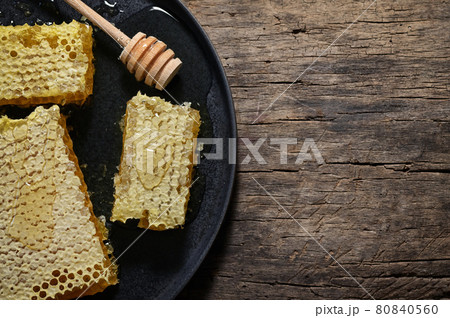 Honeycomb and honey dipper on wooden table Honeycomb and honey dipper on wooden table 80840560