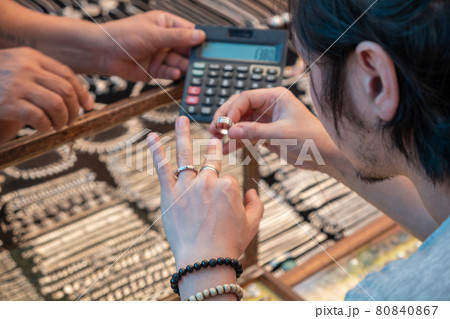 Guy tries on silver rings in india market Guy tries on silver rings in india market 80840867