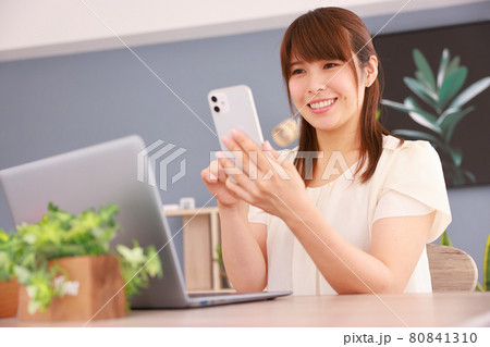 スマホを見て嬉しい気持ちになった女性 80841310