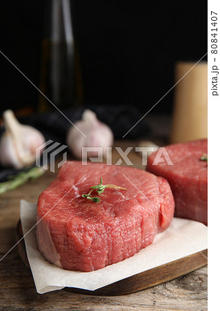 Fresh raw beef cut with thyme on wooden table, closeup 80841407