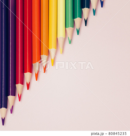 Colored pointed pencils lie on a pink background with space for copying. School supplies or school Colored pointed pencils lie on a pink background with space for copying. School supplies or school 80845235
