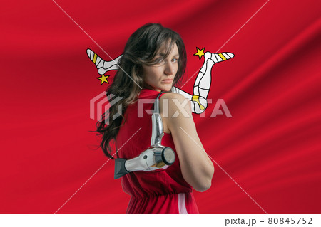 Beauty industry in Isle of Man. Happy female hairdresser holding hairdryer against Isle of Man flag background 80845752