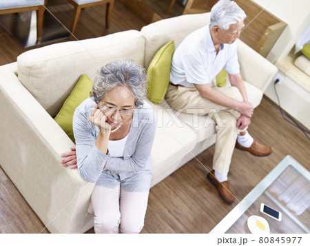 senior asian couple sitting on couch at home, angry at each other, high angle view 80845977