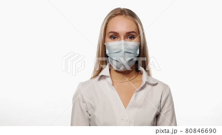 Young nurse in a medical mask nod head as agreement, looks at the camera. Isolated on white background. High quality 4k resolution footage Young nurse in a medical mask nod head as agreement, looks at the camera. Isolated on white background. High quality 4k resolution footage 80846690