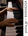 Young girl is clipping piano at home. Dark key photo 80848204