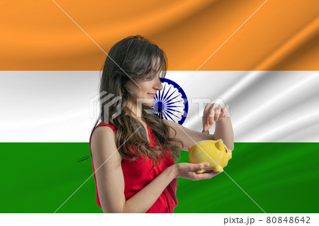 Economy in India Accumulating and saving money in India Woman putting money coin in piggy bank for saving money and plan finance 80848642