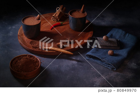 Making spicy hot cocoa drink from real cocoa powder. Tasty healthy drink for breakfast, brunch or dinner. Dark background table. Making spicy hot cocoa drink from real cocoa powder. Tasty healthy drink for breakfast, brunch or dinner. Dark background table. 80849970