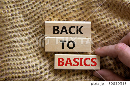 Wooden blocks form the words 'back to basics' on canvas background. Male hand. Business and educational concept. 80850513