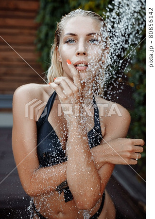 woman In Swimsuit Showering Under Water, Washing Hair, Cleaning Body Outdoors At Luxury Spa Resort In Summer. fashion model woman In Swimsuit Showering Under Water, Washing Hair, Cleaning Body Outdoors At Luxury Spa Resort In Summer. fashion model 80856142