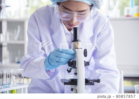 Closeup Woman scientist hand use dropper in lab look at science microscope medical test, research biology chemistry. Females technician laboratory analyzing blood scientific pharmaceutical research. Closeup Woman scientist hand use dropper in lab look at science microscope medical test, research biology chemistry. Females technician laboratory analyzing blood scientific pharmaceutical research. 80857857