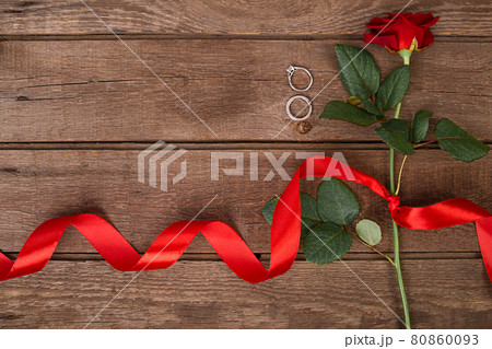 Present for St. Valentines Day - Red rose with ribbon on dark wooden background copyspace 80860093