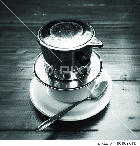 Vietnamese black coffee brewed in French drip filter on wooden table 80863689
