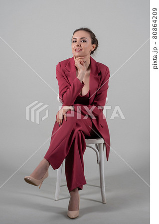 chic business lady sit chair wear red suit high-heels isolated grey background chic business lady sit chair wear red suit high-heels isolated grey background 80864209