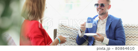 Young man and woman drinking coffee and communicating in cafe 80864610